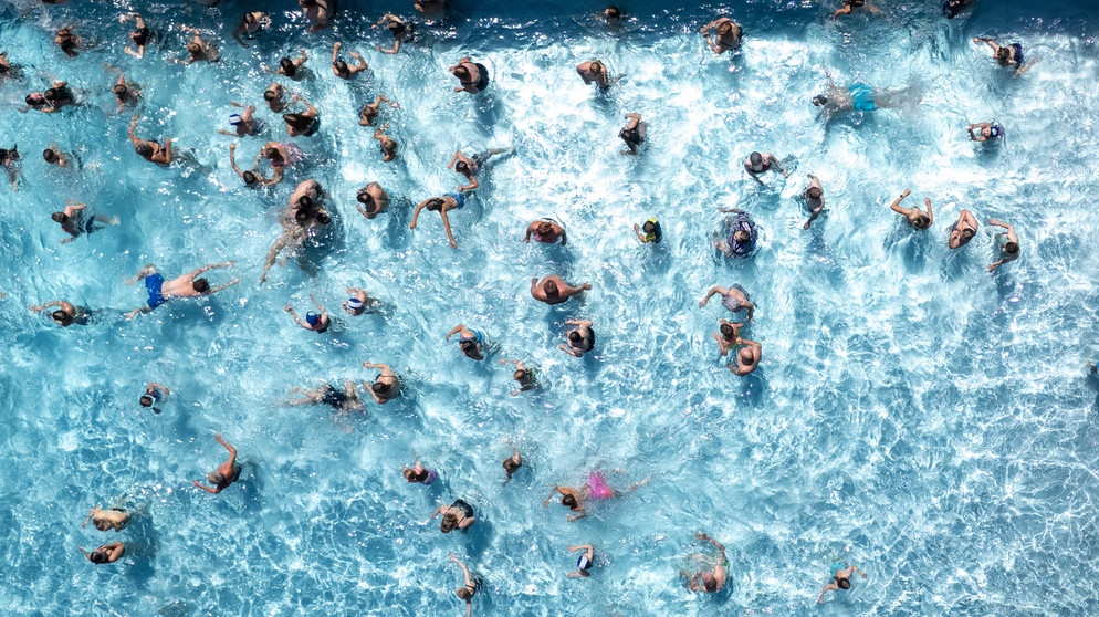 Zahlreiche Badegäste planschen im Freibad. Das Freibad hat eine sehr lange Tradition und Geschichte in Deutschland. | Bild: picture alliance/dpa | Sebastian Kahnert